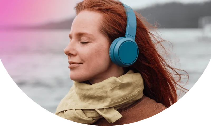 Woman with eyes closed listening to Calm through wireless headphone
