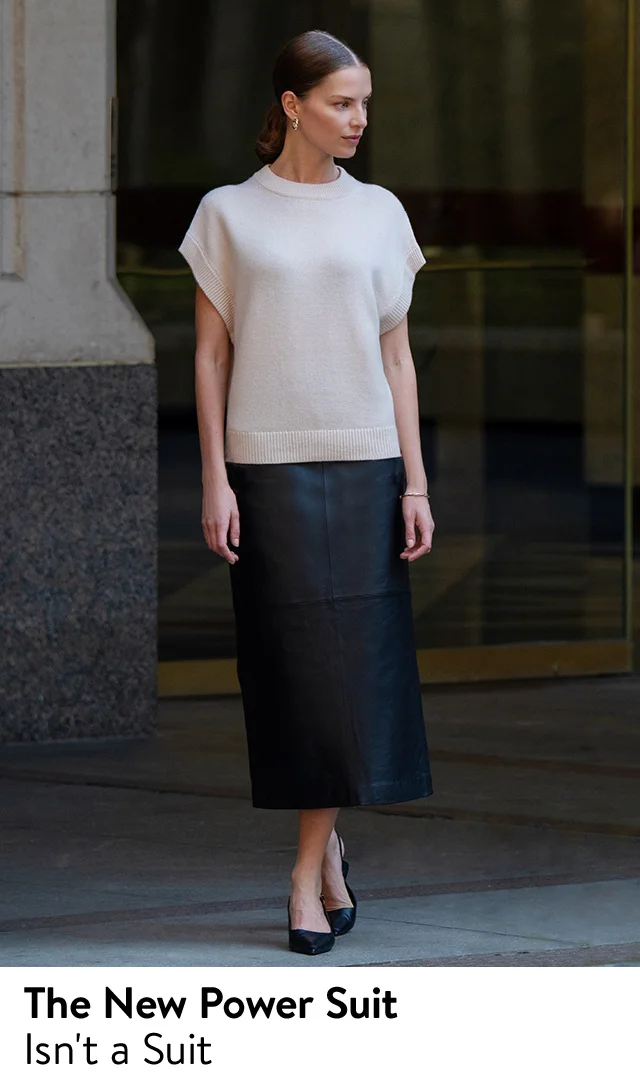 A woman wearing a white short-sleeve knit top and a black skirt.