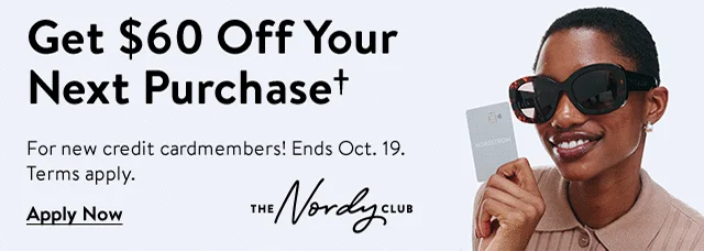 Woman smiling and holding a Nordstrom Visa® credit card.