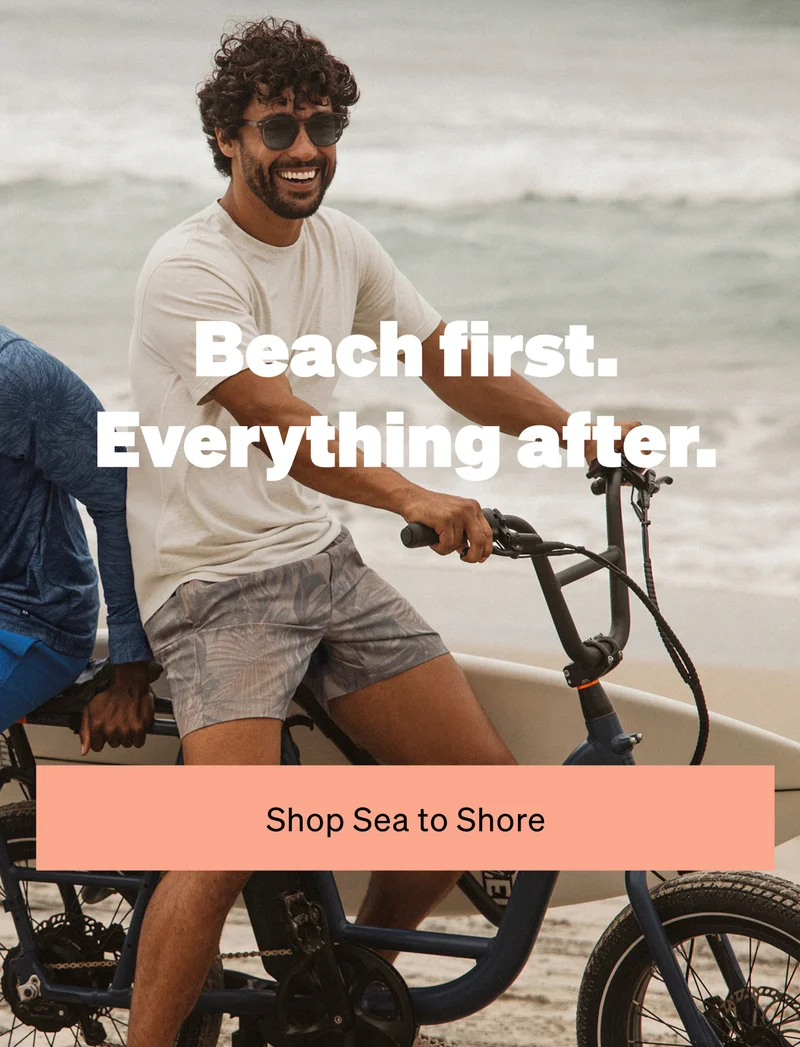 Man riding a bike by the beach wearing swim shorts with “Beach first. Everything after.” text overlay