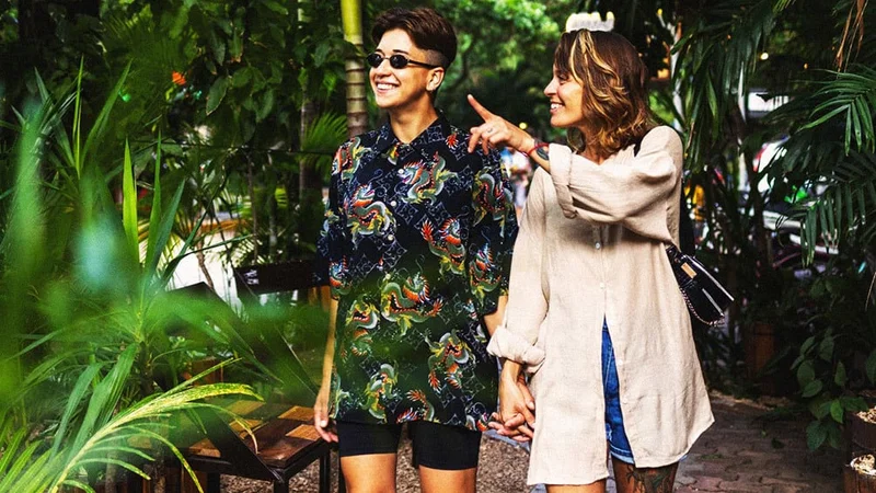 Image description: Two people walking through a tropical rainforest