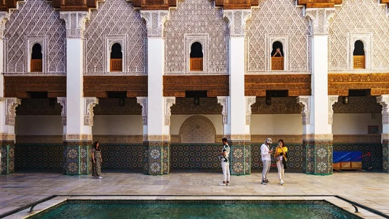 Image description: Tourists at Madrasa Ben Youssef, in Marrakesh, Morocco.