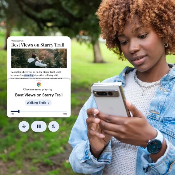 A woman standing in front of trees and a green lawn looking at the screen of a white Pixel phone. A text bubble is overlaid on the image and shows an audio player icon beneath a webpage titled “best views on starry trail.”