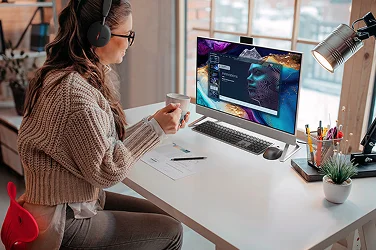 An over-shoulder view of a remote worker reviewing a presentation on a Dell All-in-One Desktop computer.
