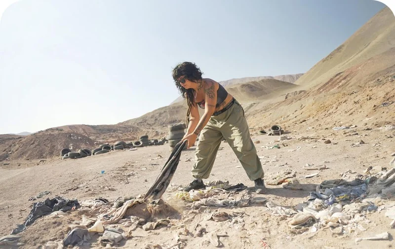 A person pulling clothing out of the dirt.