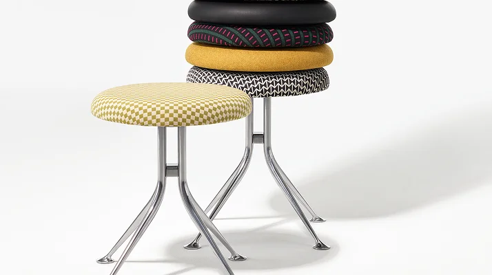 A stack of cushions on a Girard Stool, showing the wide variety of fabric choices and personalities that can be put on the seat.
