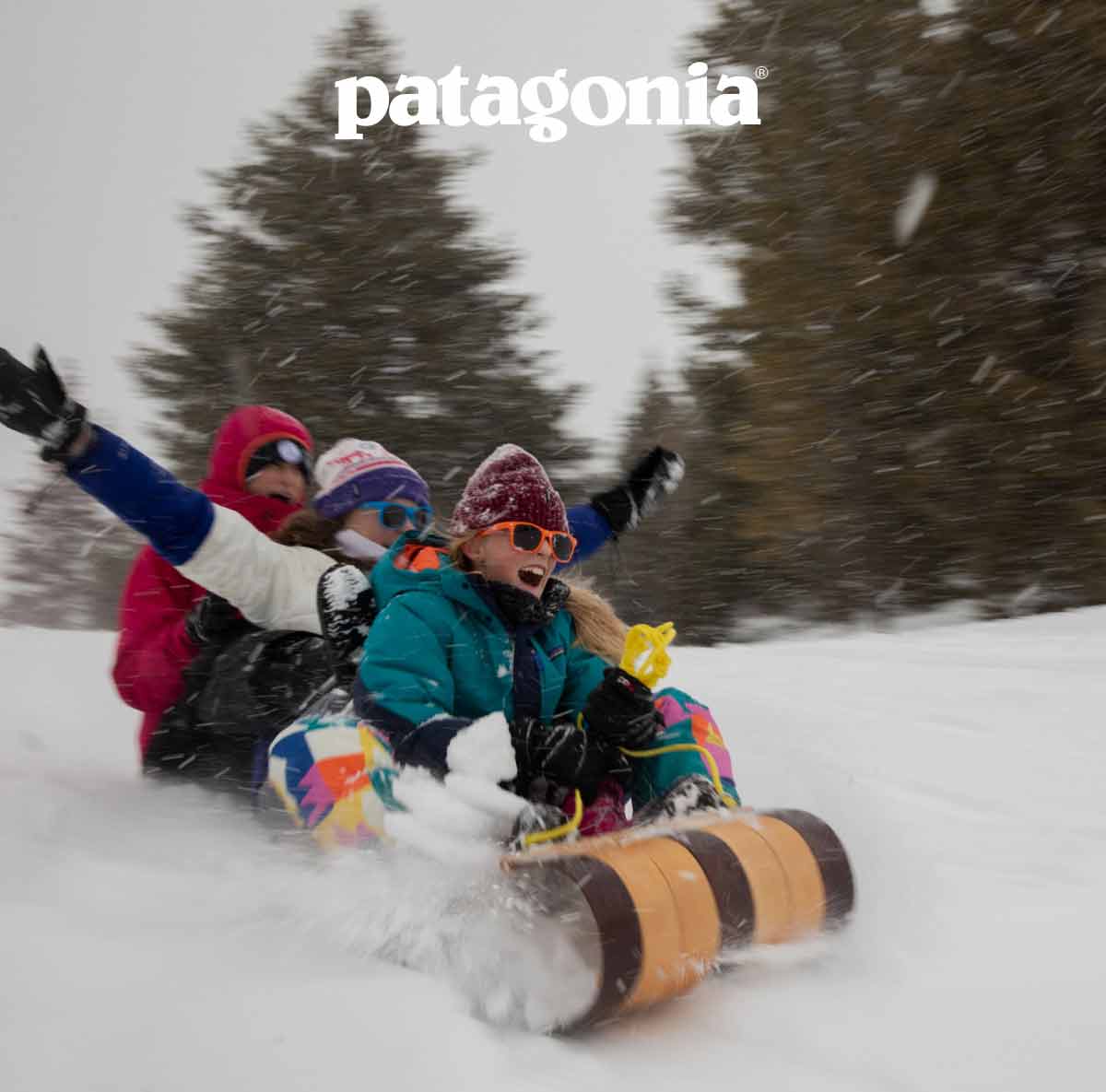 Patagonia. Three people riding a toboggan in the snow.
