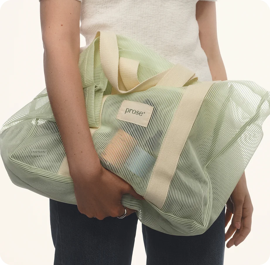 Person holding Prose Mesh Beach Tote full of Prose haircare products Person holding Prose Mesh Beach Tote full of Prose haircare products