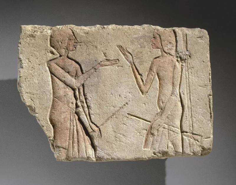 A photograph of limestone engraved with two people talking