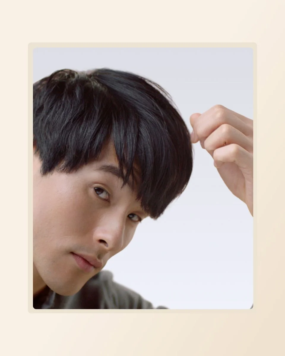 Model applies the finishing touches to his short hair style after using the Dyson Supersonic hair dryer
