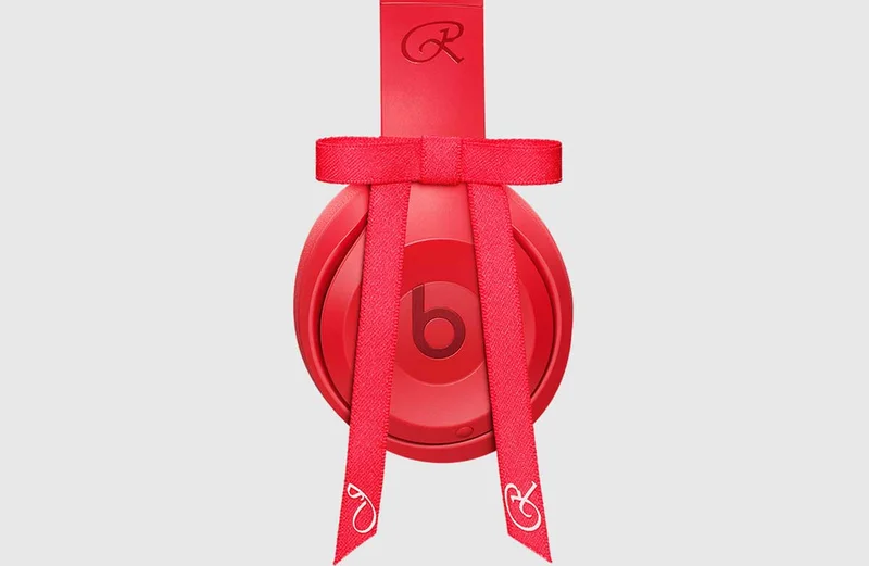 Side view of the Beats Solo 4 – JENNIE Special Edition headphones in Ruby Red, showing the “b” logo and red bow detail.