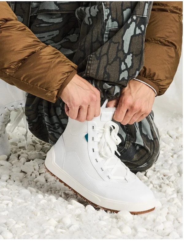 Picture of a male model putting on the Alta High Top.