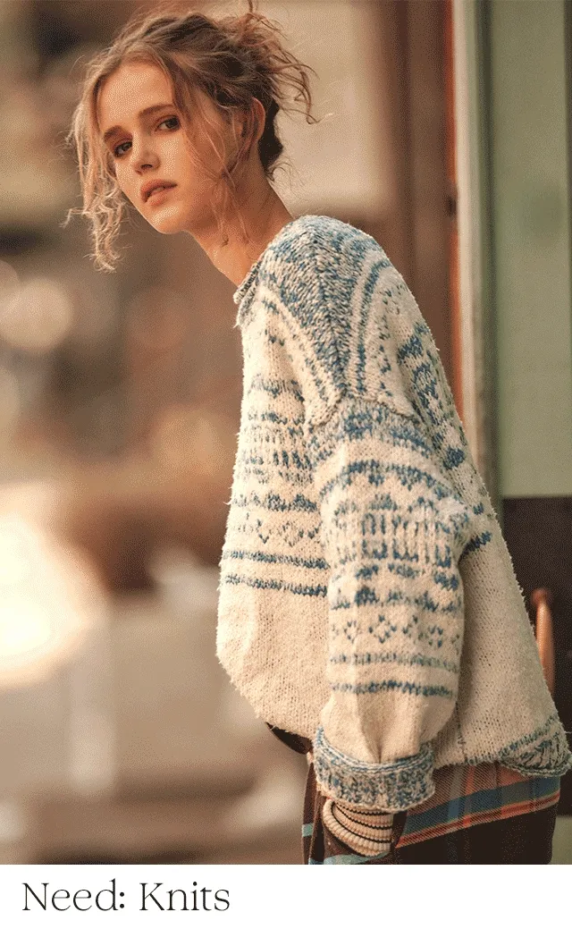 A woman wearing a blue and white sweater with plaid pants.