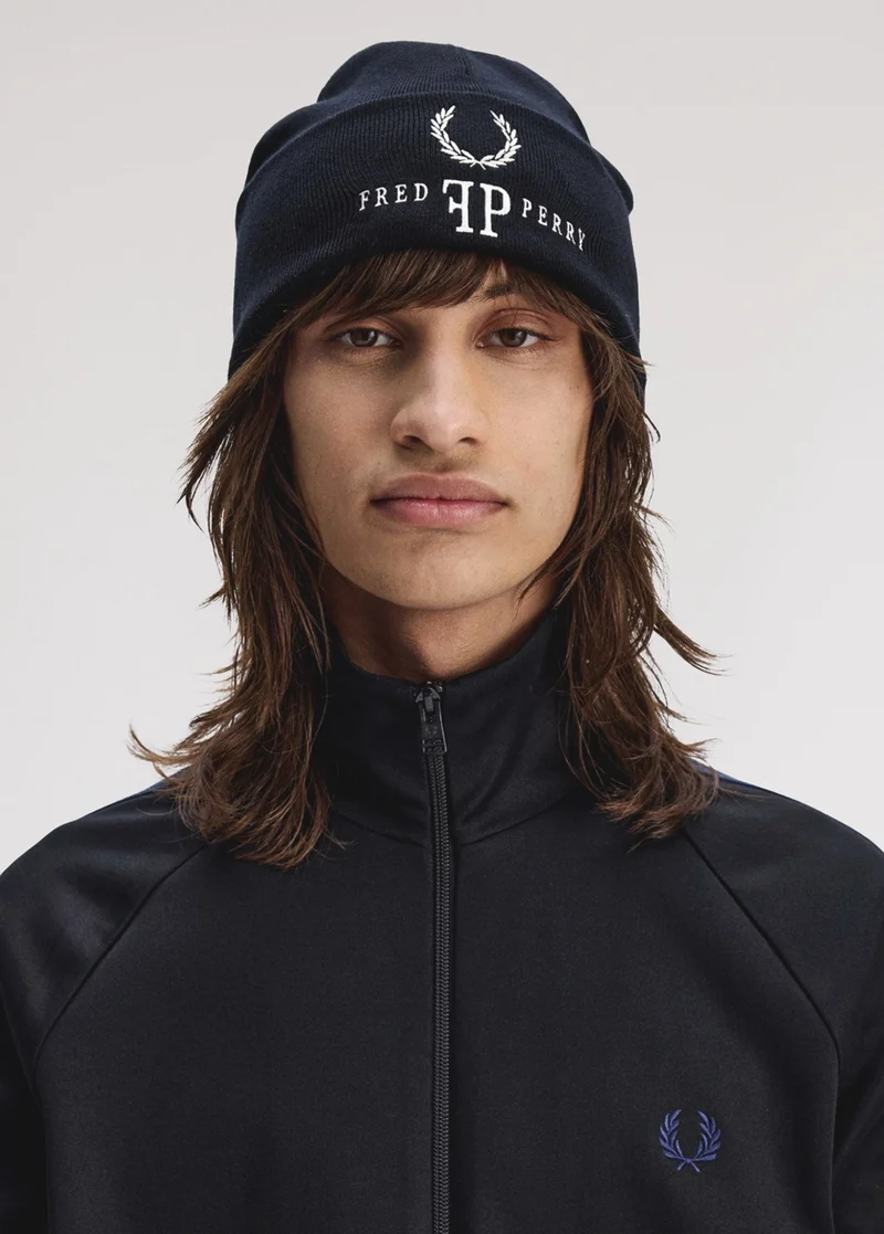 image shows the back of a male model who is wearing a pale blue sweatshirt with dark logo embroidery on the back