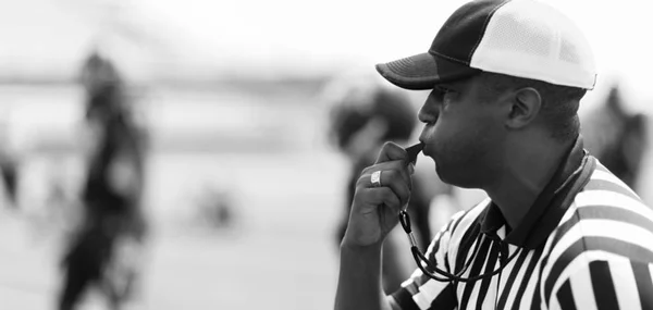 Referee blowng whistle