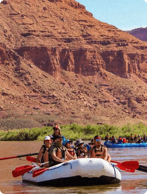 Image Description: A group of travelers rafting through the red rock canyons on the Colorado River