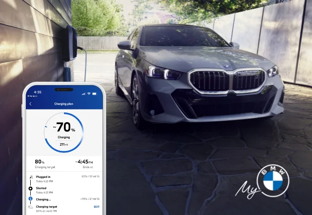 A photo of a BMW i5 sedan parked in a garage with the My BMW app showing the vehicle's charging status and trip overviews.