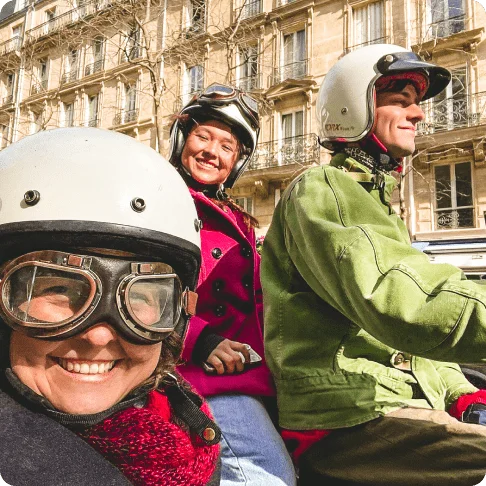 Image Description: Close-up shot of two people seemingly on a motorcycle with a third person in the sidecar.