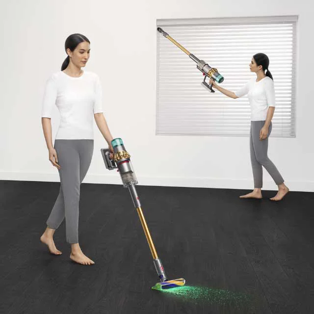 Woman cleaning living area with a Dyson V15 Detect vacuum