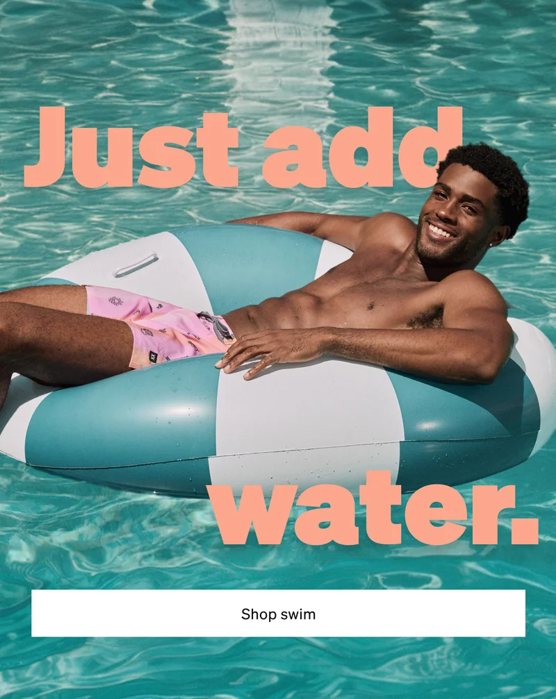 Smiling man floating in a pool wearing pink swim shorts beside text “Just add water” with Shop Swim button.