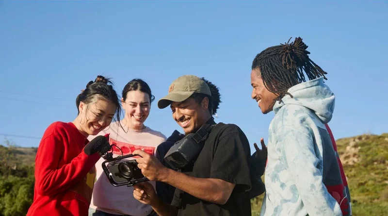 Image of 4 people reviewing footage on a phone