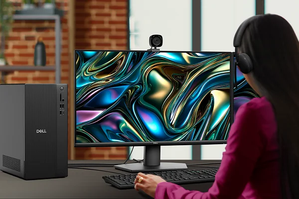 Over-shoulder view of a woman working on a Dell Tower Desktop                               computer in an office setting.