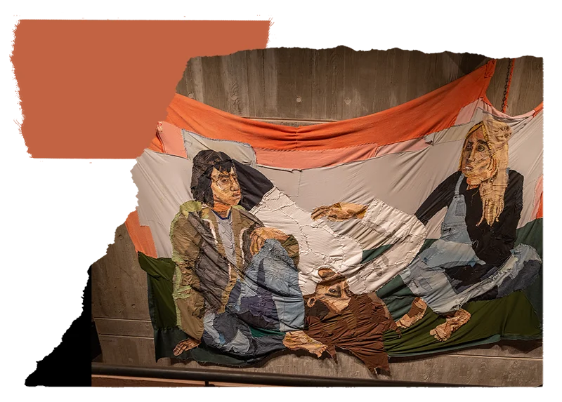 Textured tapestry art by Julia Gutman, depicting a scene with three figures in a state of repose, crafted in rich, earthy tones and installed against a wooden wall.