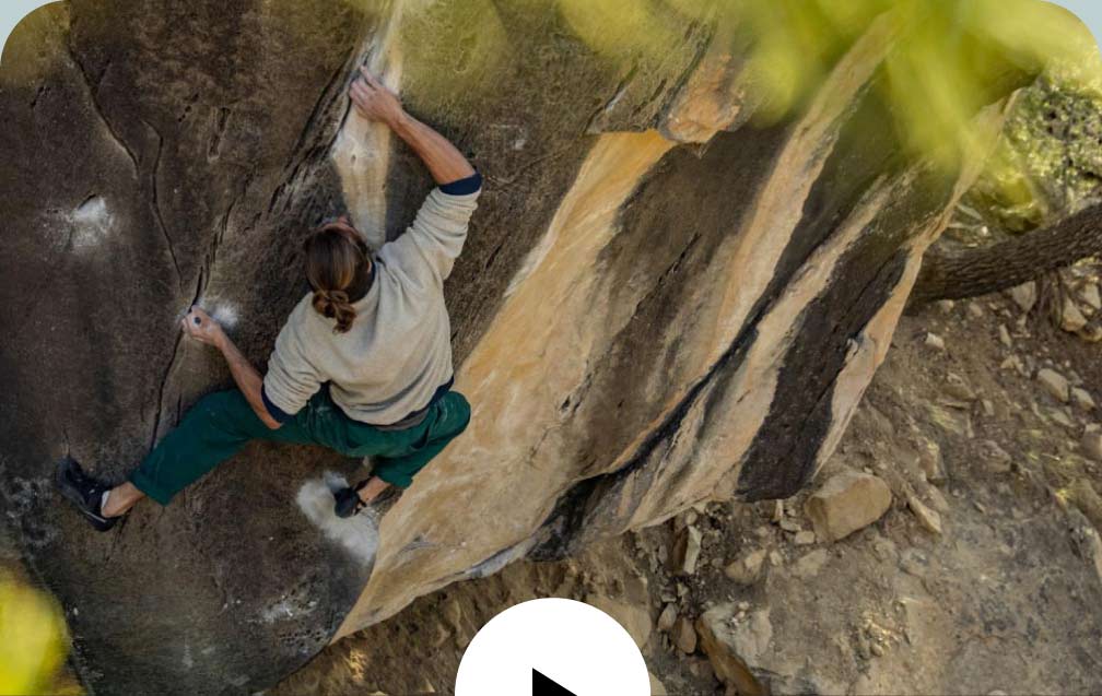 A climber looks for a hold on a bouldering problem.