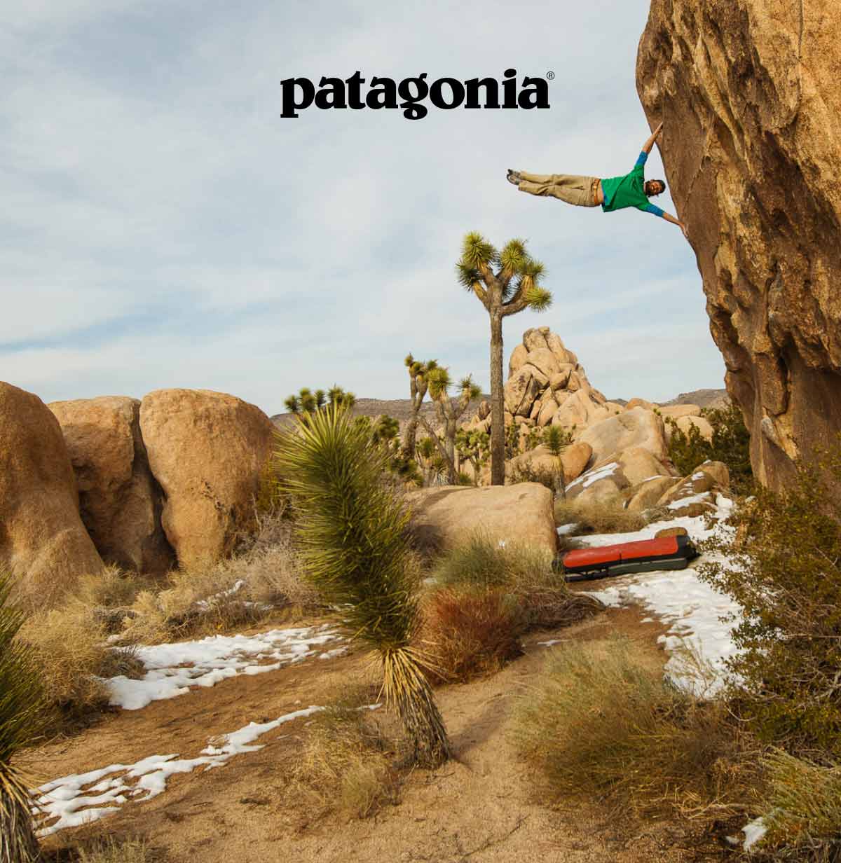 A climber sticks their legs straight out from the rock to look like a flag blowing in a stiff wind.
