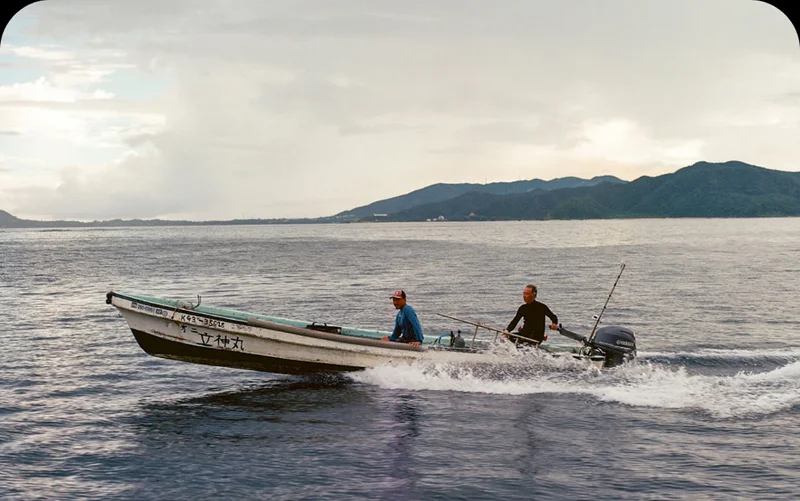Two people traveling through water on a boat.
