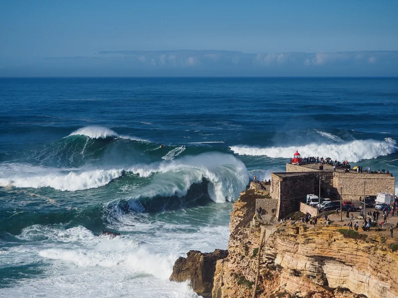 Crowds watch big-wave surfers from a lighthouse in 2020.