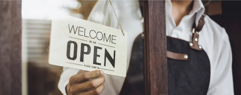 Business owner turning around an open sign