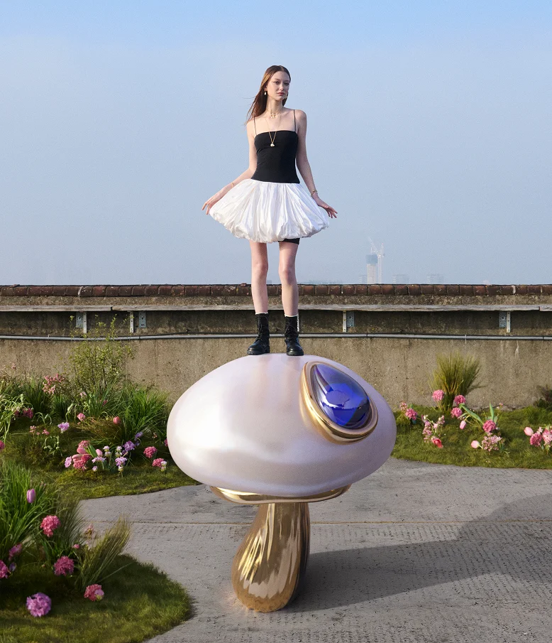 A model stands on a super-sized mushroom pearl charm
