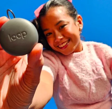A smiling woman holds a Loop Carry Case up to the camera.
