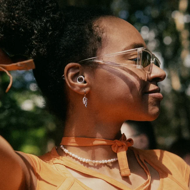 Two women dancing in front of a DJ booth at a party.