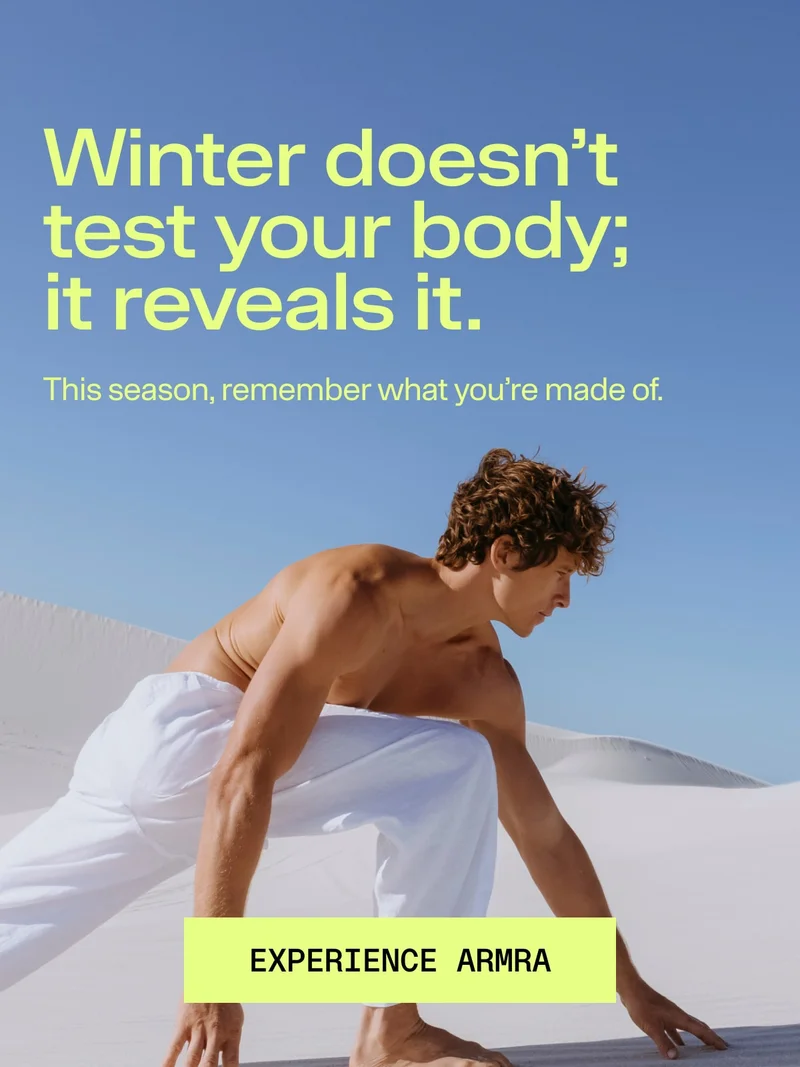Person in a low athletic stance on white sand dunes under a clear sky, representing strength, resilience, and seasonal vitality.