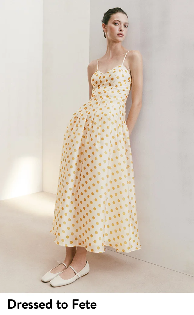 A woman wearing a polka dot dress and mary jane ballet flats.