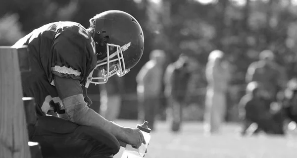 Football player sitting on bench