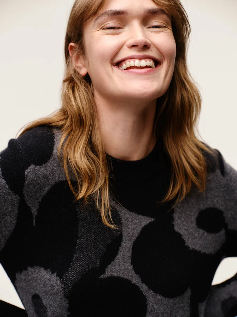 Woman laughing wearing Aukio Unikko Knitted sweater.