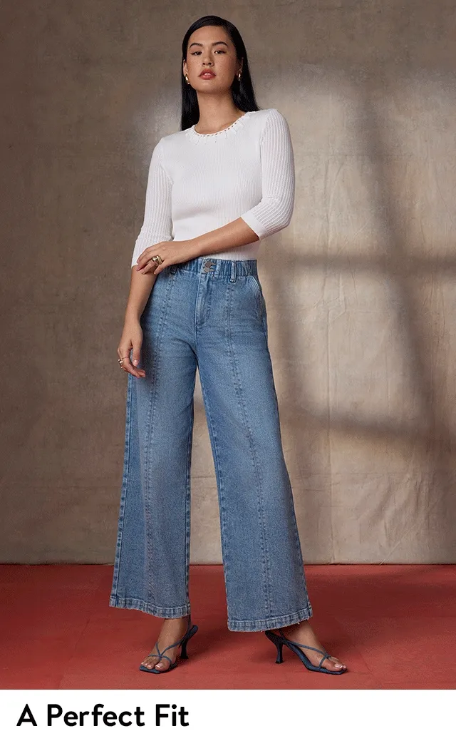 A woman wearing blue jeans with a white shirt.