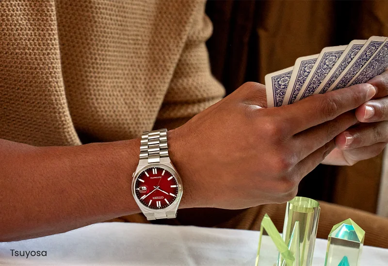 Person wearing the red dial Tsuyosa and playing cards.