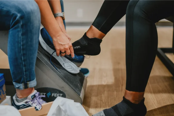 Outfitter putting a shoe on a customer's foot