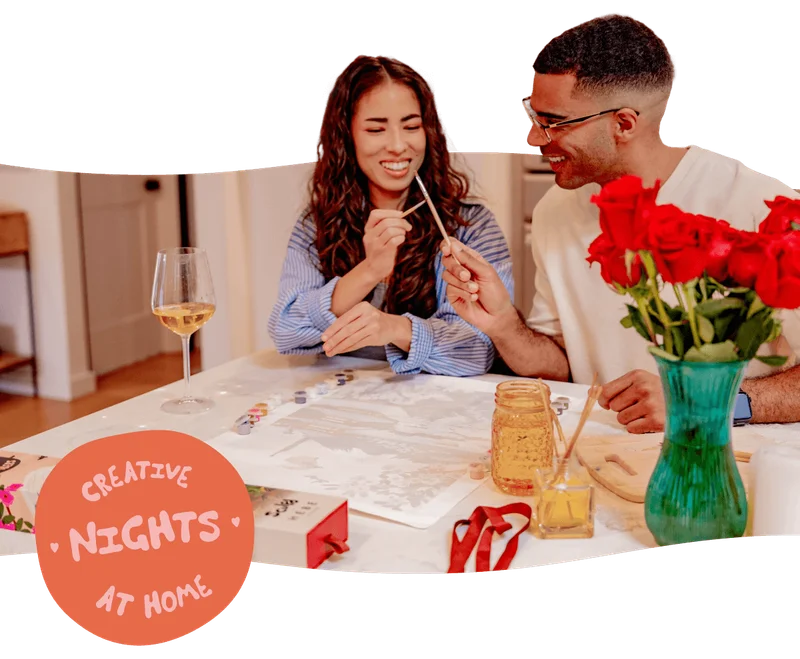 Couple smiling and painting.