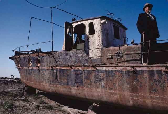 Three boats sit in the salt-encrusted desert that was the Aral Sea.