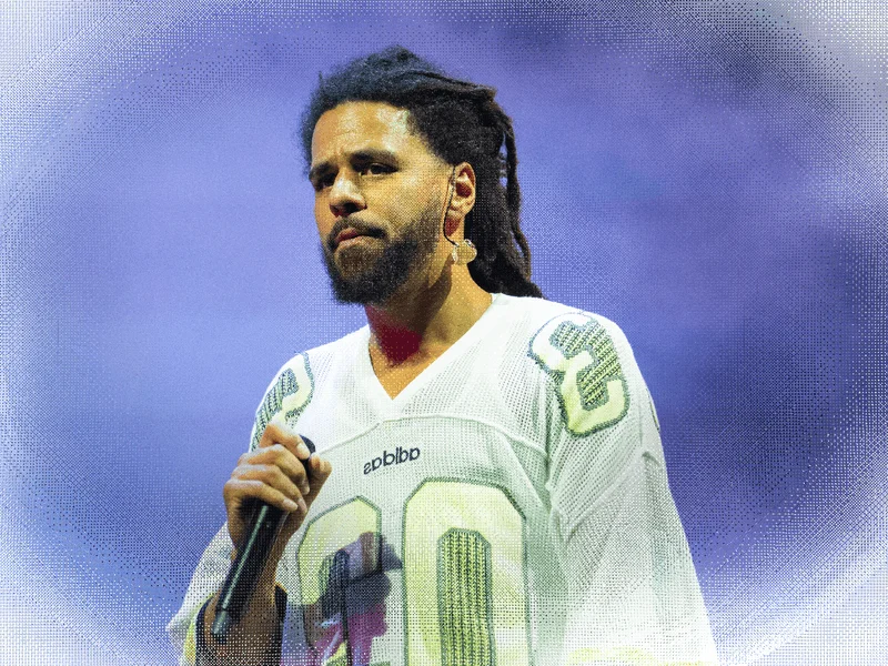 Image may contain: J. Cole, Electrical Device, Microphone, Adult, Person, People, Performer, Solo Performance, and Clothing