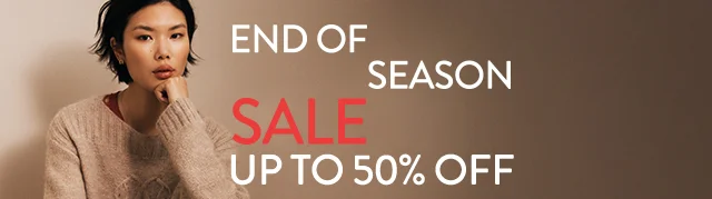 End-of-season sale: up to 50% off. A woman wearing a cozy sweater.