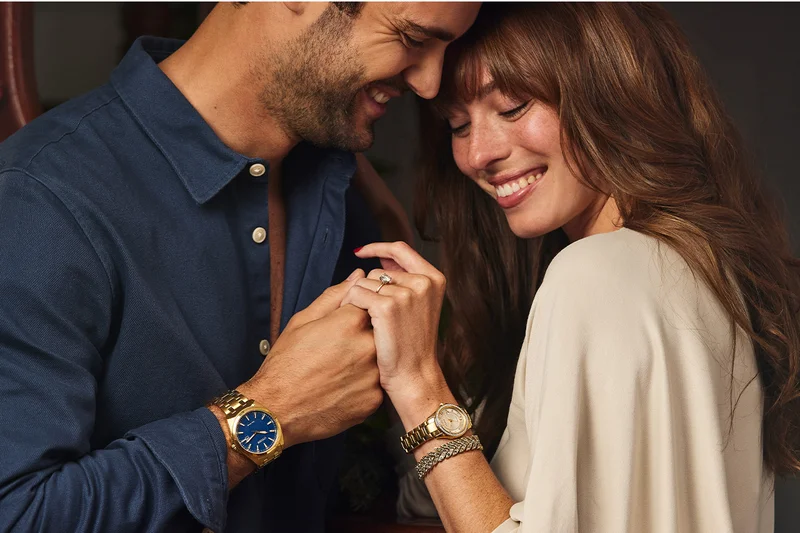 A couple wearing the elegant Payten (his) and Crystal (hers) share a warm moment of affection.