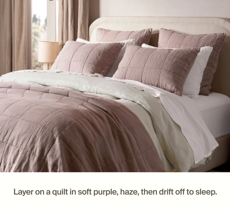 Bed styled with box quilt and quilted shams in soft purple, haze.