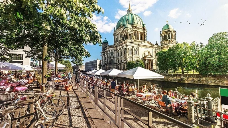 Image description: Outdoor cafe with a view of Spree River and Berliner Dom, Berlin, Germany