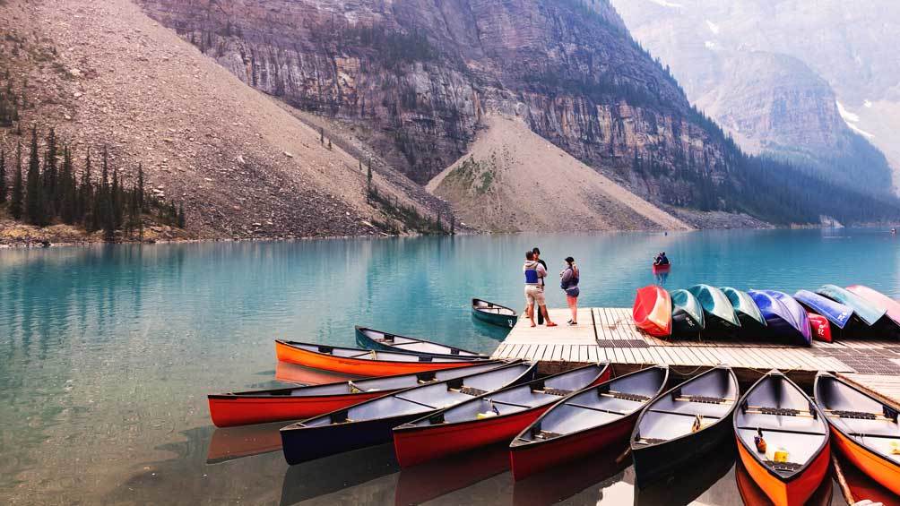 Image description: Tourists waiting to get into the boat to paddle in kayak in the waters of Lake Moraine, Banff National Park, Alberta, Canada.